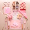 Set de cocina infantil rosado con utensilios de repostería y accesorios de madera y silicona para juego simbólico.